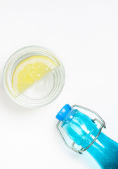 LEMON WITH MINERAL WATER AND BOTTLE ON A WHITE BACKGROUND