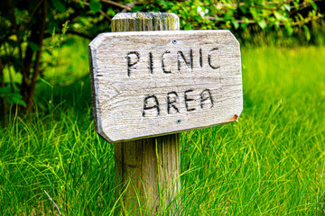 Small rustic wooden sign for "picnic area" in the grass