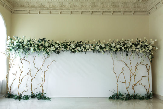Indoor wedding light photozone decorated with fresh flowers