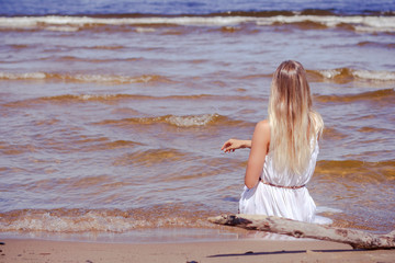 Fototapeta na wymiar Beautifil Young Woman Sitting On The Beach At Sunny Day Enjoing Summer Vacation