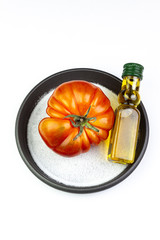 OMATO WITH OLIVE OIL AND SALT ON A WHITE BACKGROUND