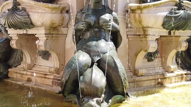 SLOW MOTION Close up on mermaid fountain of Nettuno 1567 bronze statue in front of Accursio palace, built in 1290, in Piazza Maggiore square of Bologna, Italy. SLOW MOTION