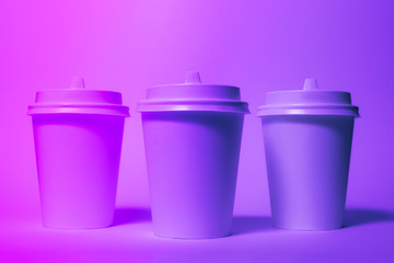 Paper disposable cups in trendy neon light.