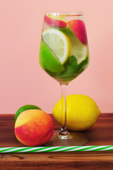 Cocktail drink with mint, lemon, lime and nectarine. Glass of summer refreshing beverage  with fruits.
