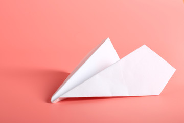 white paper plane on a pink background