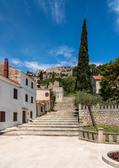 Fototapeta na wymiar Church and square with fortress on hilltop in the coastal town of Novigrad in Croatia