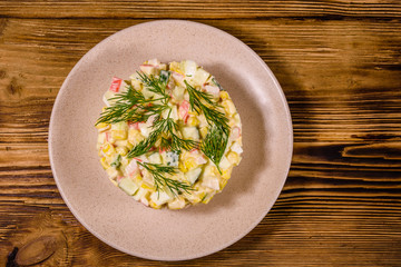 Salad with crab sticks, boiled eggs and cucumbers on a ceramic plate. Top view