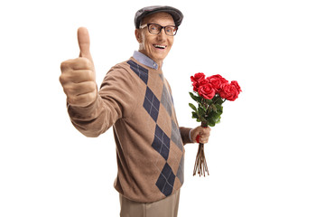 Elderly man holding a bunch of red roses showing thumbs up
