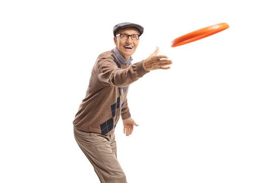 Cheerful elderly man playing with a frisbee