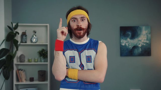 Creative funny retro sportsman coming up with a nice idea while training on math at home. Portrait of attractive fun berded hipster in sport clothing.