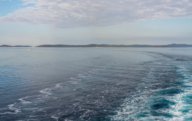Calm Adriatic sea with islands off the coast of Croatia as ship approaches port of Zadar
