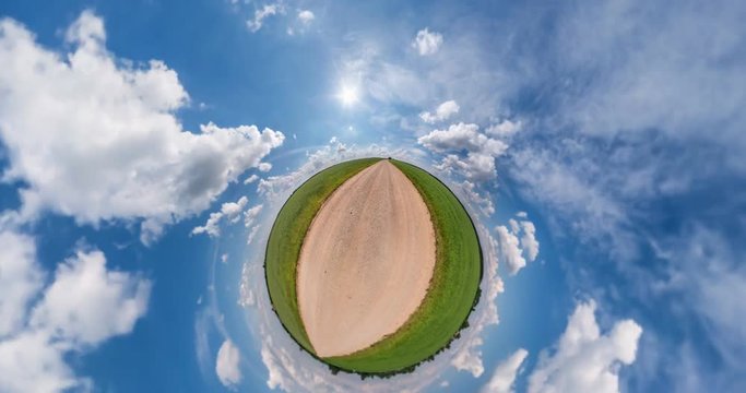 NO VR. Curvature of space of little planet transformation. Abstract torsion and spinning of full flyby panorama landscape on gravel road in sunny day with awesome clouds.