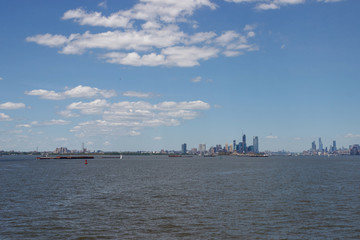On the horizon are seen the skyscrapers of New York. Skyscrapers of New York in the distance. Bay, blue sky, sunny summer day in New York.