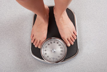 Happy Woman smiling on weighing scales