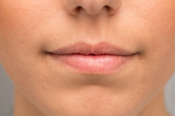 A close-up view on the soft lips of a beautiful young Caucasian woman. Flawless skin and closed lips.