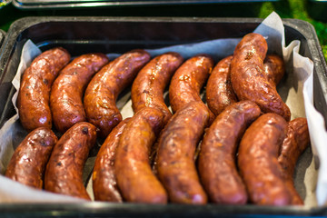 Lots of fried sausages on the counter of street vendors. Fast food.