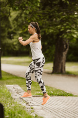  A beautiful fitness girl trains in the park. Nature and healthy life