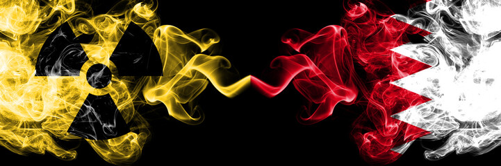 Bahrain, Bahrani vs nuclear smoky mystic flags placed side by side. Thick colored silky smokes combination of Bahrain, Bahrani flag and radioactive sign.