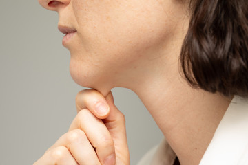 A closeup and side profile view of a thirty something Caucasian girl, of slim build, squeezing the...