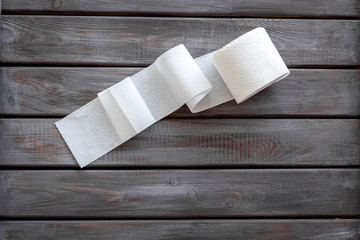 Proctology concept with toilet paper on wooden background top view