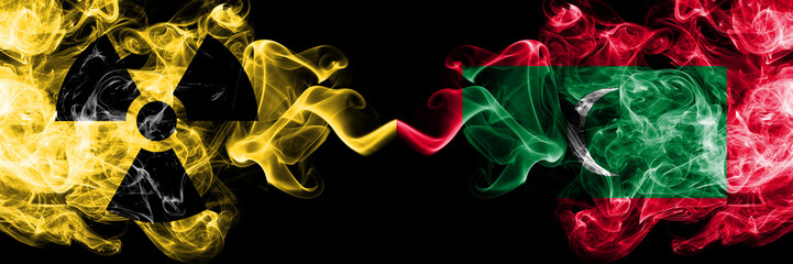 Maldives, Maldivian vs nuclear smoky mystic flags placed side by side. Thick colored silky smokes combination of Maldives, Maldivian flag and radioactive sign.