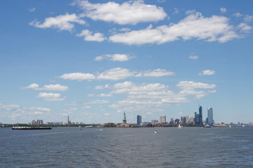 On the horizon are seen the skyscrapers of New York. Skyscrapers of New York in the distance. Bay, blue sky, sunny summer day in New York.