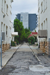 Obraz premium Looking down the long empty back road pathway in the downtown city area of the metro. 