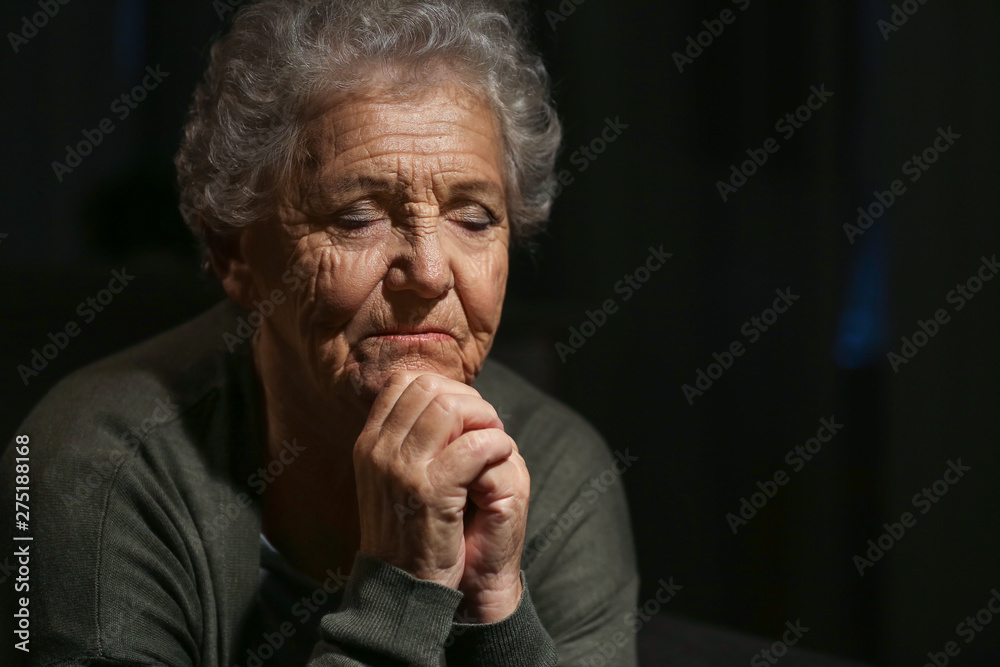 Canvas Prints senior woman praying to god on dark background