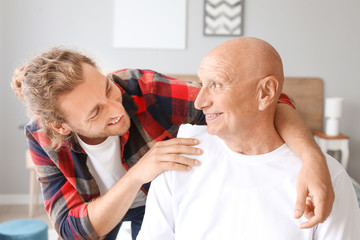 Young man visiting his father in nursing home