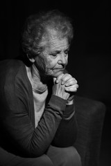 Black and white portrait of praying senior woman