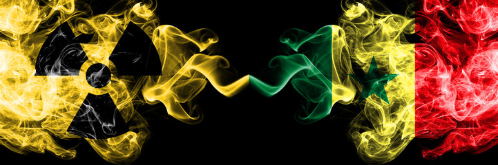 Senegal, Senegalese vs nuclear smoky mystic flags placed side by side. Thick colored silky smokes combination of Senegal, Senegalese flag and radioactive sign.