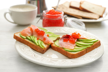 Plate with tasty avocado toasts on table