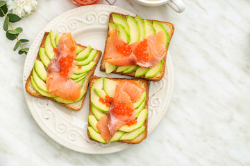 Plate with tasty avocado toasts on table
