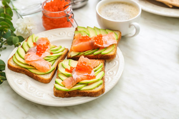 Plate with tasty avocado toasts on table