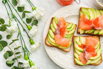 Plate with tasty avocado toasts on table