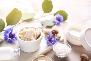 Shea butter with cosmetic products on table
