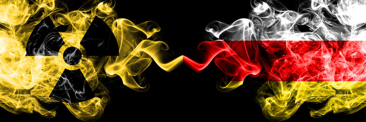 South Ossetia vs nuclear smoky mystic flags placed side by side. Thick colored silky smokes combination of South Ossetia flag and radioactive sign.