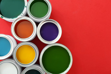 Cans of paints on color background