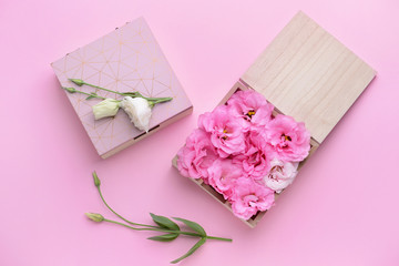 Boxes with beautiful fresh flowers on color background