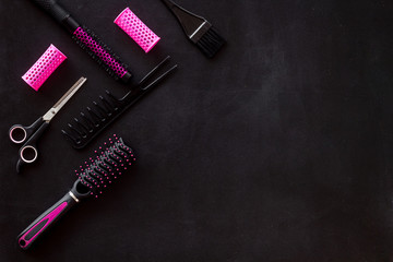 Set of professional hairdresser tools with combs, sciccors and styling on black background top view...