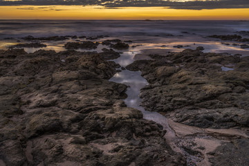 Dusk over the ocean with purple and golden sky