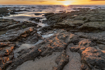 Sunset reflection on rocky coastline