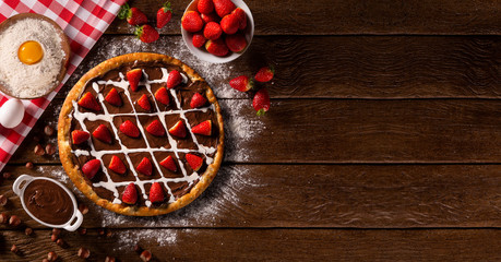 brazilian sweet pizza with hazelnut cream and strawberry on wood background.