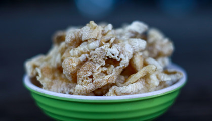 Chicken feet crackers or kripik ceker on wood background. 