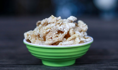Chicken feet crackers or kripik ceker on wood background. 