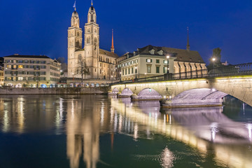 View of Grossmunster and Zurich old town from Limmat river. The Grossmunster is a Romanesque-style Protestant church in Zurich, Switzerland.
