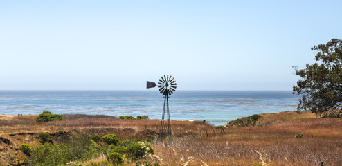 A windmill in the field along the coast in California. 