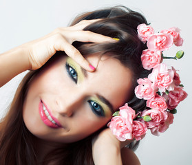 young pretty brunette woman with pink flowers and manicure posing cheerful isolated on white background closeup