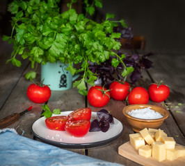 Rural sketch, a small lunch of cheese and red tomato. Parsley greens in a ceramic mug.