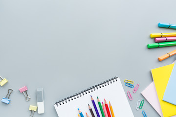 School supplies stationery, colour pencils, clips, paper on gray background, back to school concept...